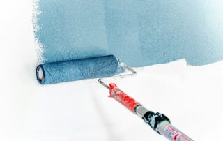 a roller painting a wall