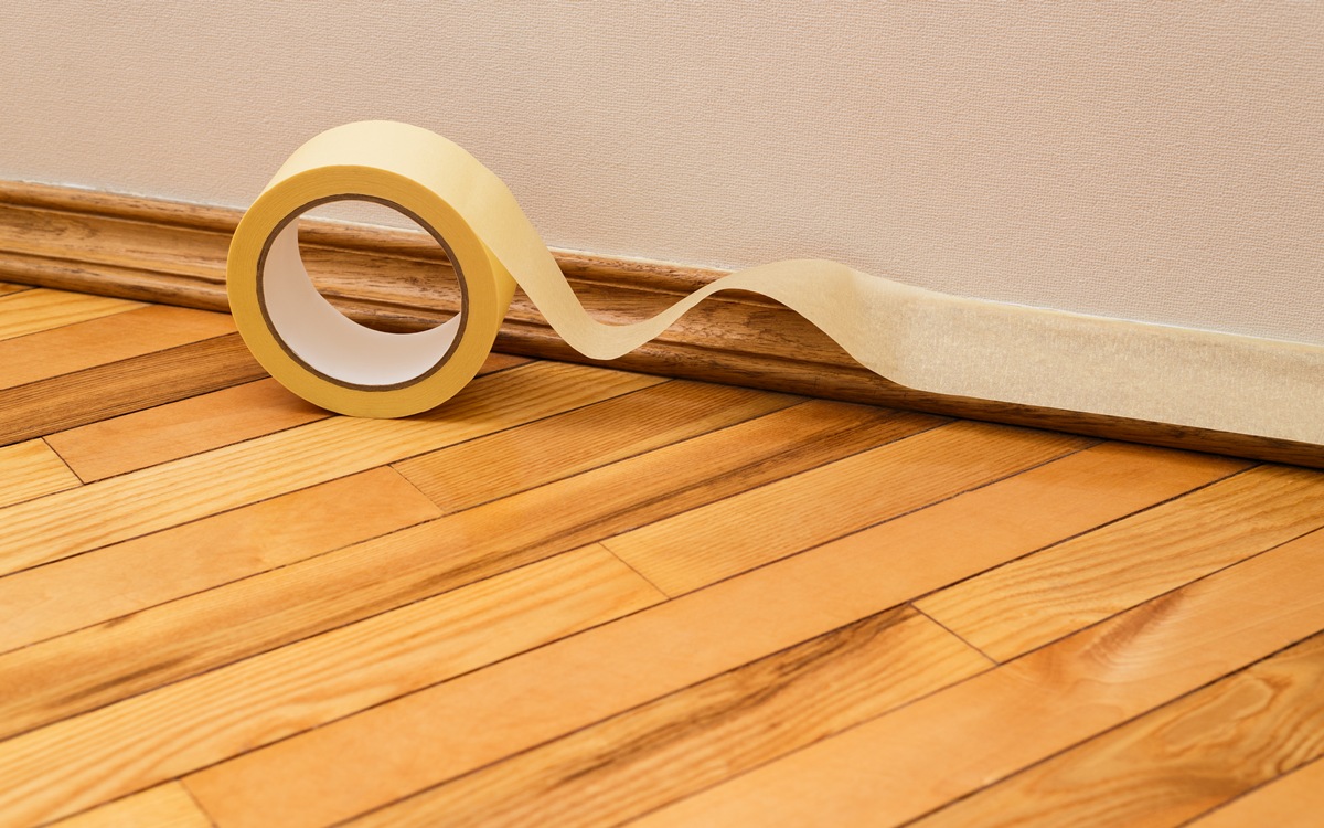 Sticking masking tape to the baseboard