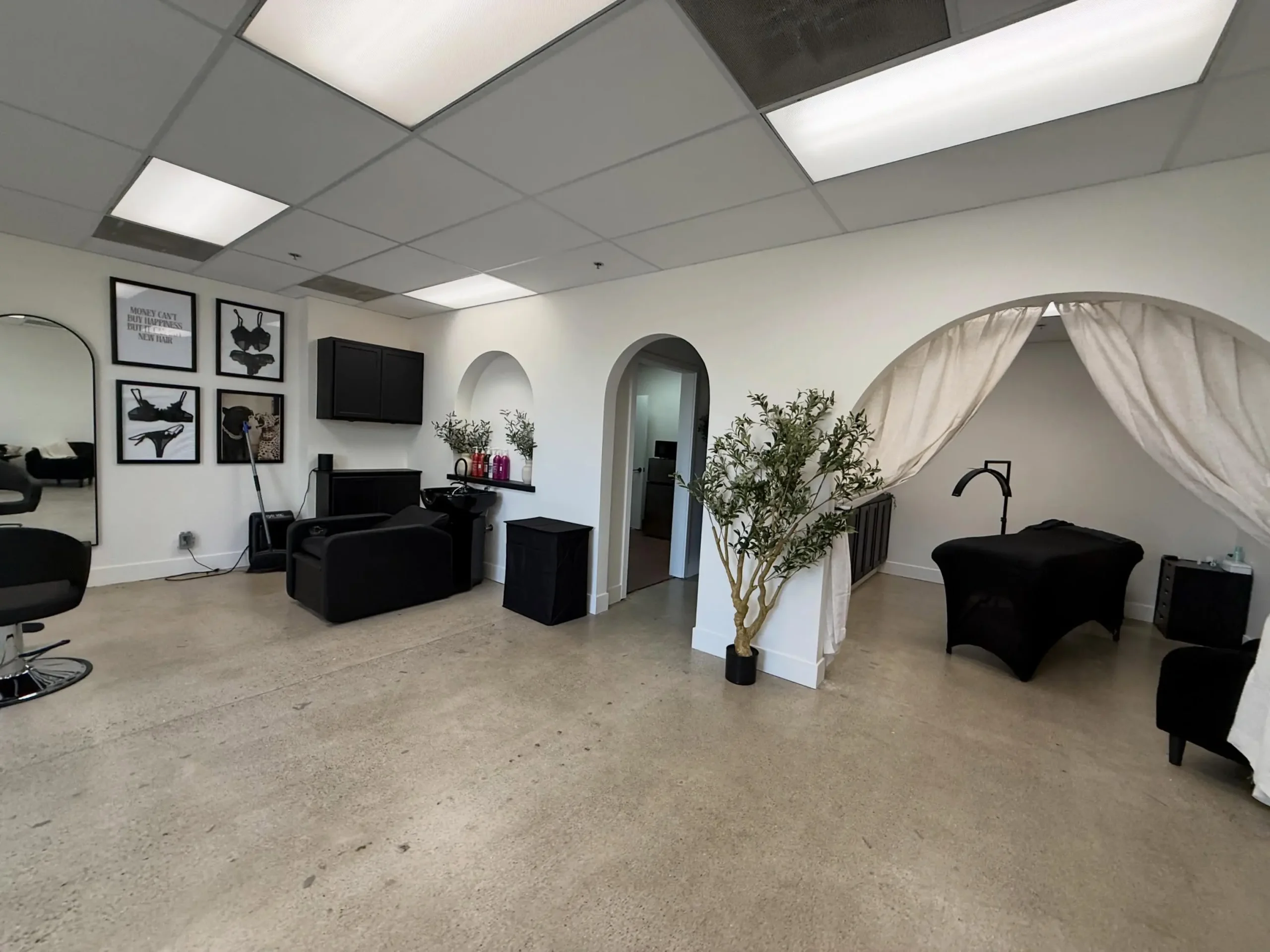 Professional Interior Painting for Salons and Spas Freshly painted white walls in a modern salon or spa interior with black furniture and concrete floor.